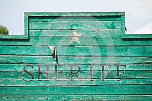 Old, western style green wooden Sheriff sign