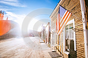 Old Western Wooden Buildings with flag of the united states, in St. Elmo Gold Mine Ghost Town in Colorado, USA