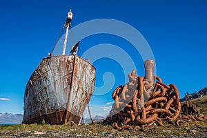 Old whaler with harpoon beside rusty chain photo