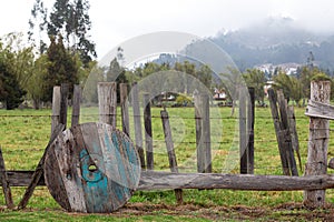 Old wheel lying on a wooden fence