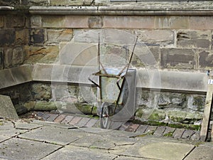 Old wheelbarrow againts the wall