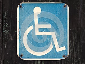 Old wheelchair sign on a wooden wall