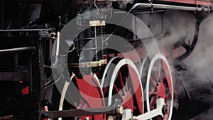 Old wheels and parts of a steam engine close-up. Soviet locomotive stands
