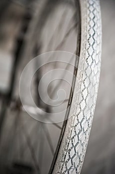 Old white bicycle whist on a white stone wall.