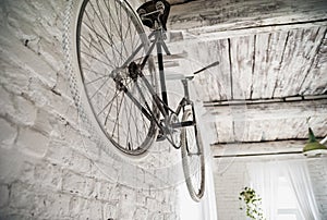 Old white bicycle whist on a white stone wall.