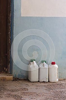 Old white bottles of insecticide next to a wall