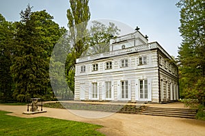 old white building standing between trees in a park