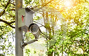 Old white cctv camera or surveillance on the pole for monitoring in public park