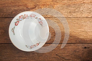 Old white ceramic dish on wood background