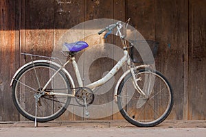 Old white color bicycle parking at front of wooden pattern