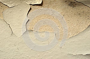 Old white concrete wall, background, texture. The shabby, splintering white paint from the concrete wall