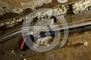 Old white electrical wires in a broken wall