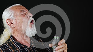 Old White Haired Man is Drinking Water From Plastic Bottle