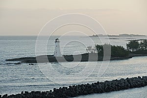 Old white lighthouse on a breakwater at the entrance to Nassau harbour in the Bahamas.