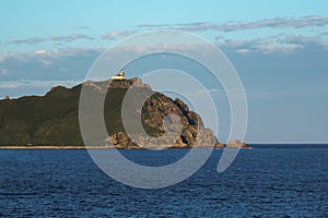 old white lighthouse on a cliff