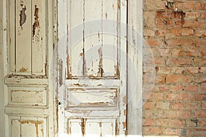 Old, white painted doors, closed, indoors with red brick walls