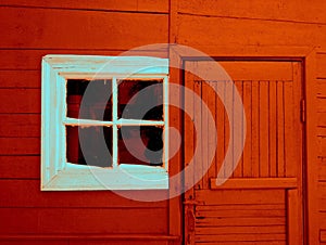 An old white-painted window on a red house