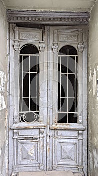 Old white painted wooden door with windows in a abandoned house.
