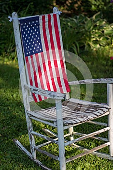 Old white rustic rocking chair with United States flag