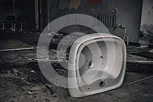 An old white sink in an abandoned building.