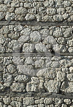 Old white stone wall  with wooden beams closeup