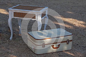 Old white suitcase on grass .