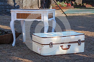 Old white suitcase on the grass.