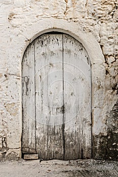 Old white timber door in the scuffed wall