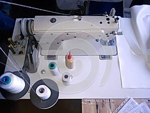 Old white vintage hand sewing machine. A man is sewing