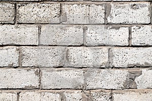 An old white wall made of rough ceramsite concrete blocks as a background