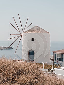 Old white windmill on the cliff in Santorini