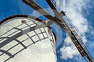 Old white windmills, made of stone, on the field with blue sky and white clouds. La Mancha, Castilla, Spain photo