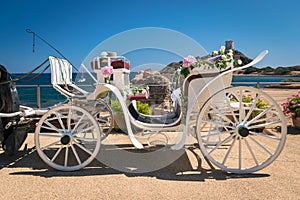 Old white wooden carriage during a wedding on the sea.