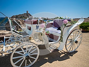 Old white wooden carriage during a wedding on the sea