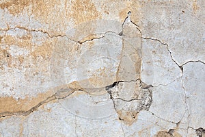 Old whitewashed background texture of a weathered distressed cracked concrete cement stone wall