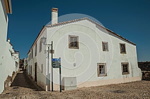 Old whitewashed house in front a cobblestone square