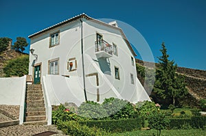 Old whitewashed wall house with stairs and green garden