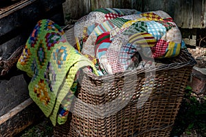 Old wicker basket filled with hand made quilts and blankets