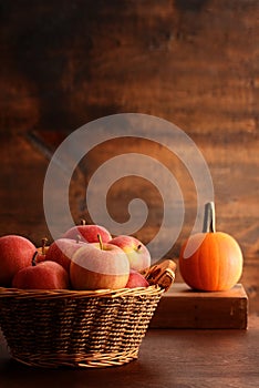 Old wicker basket with royal gala apples and pumpkin