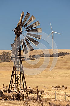 Old wind pump and new wind generators distorted by hot air. South Australia.