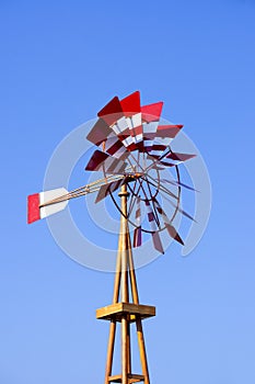 An old windmill with a clear, cloudless blue sky