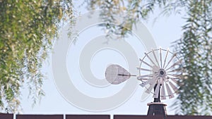 Old windmill generator on ranch or farm, vintage wind mill propeller in USA.