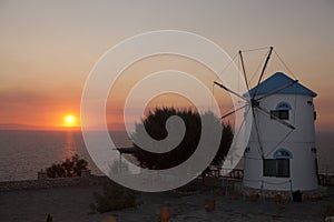 Old windmill on Greece island on the sea beach