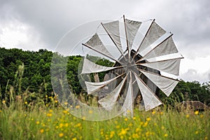 Old windmill in green field