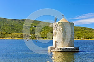 Old windmill in harbor of orbetello