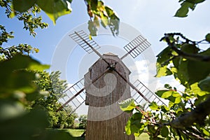 Old windmill on a hill in the rays of the sun at sunset, green fields. Spring rural landscape with an old mill. Stary Podvorov, So