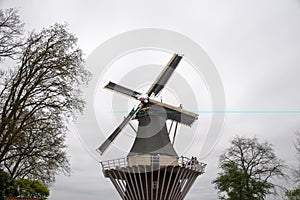 Old windmill with many people in famous garden in Keukenhof