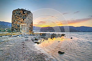 Old windmill ruin on Crete at sunset