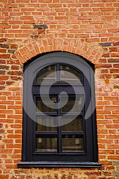 Old window on the background of a yellow brick wall