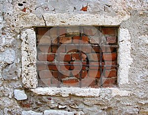 Old window blocked with grates and bricks photo